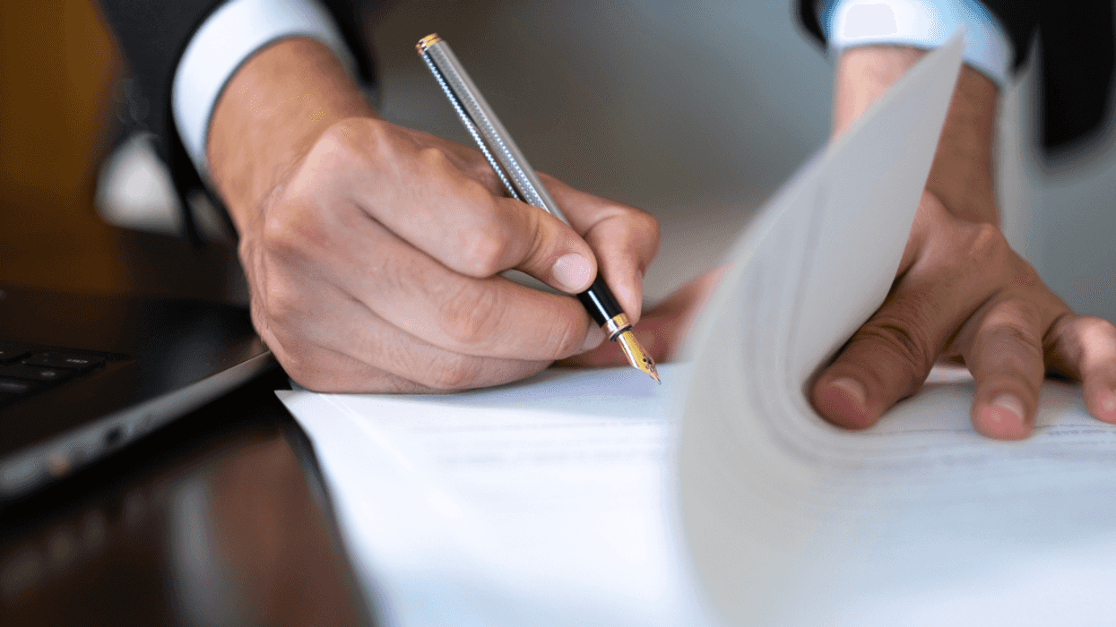 A man signing a paper document.