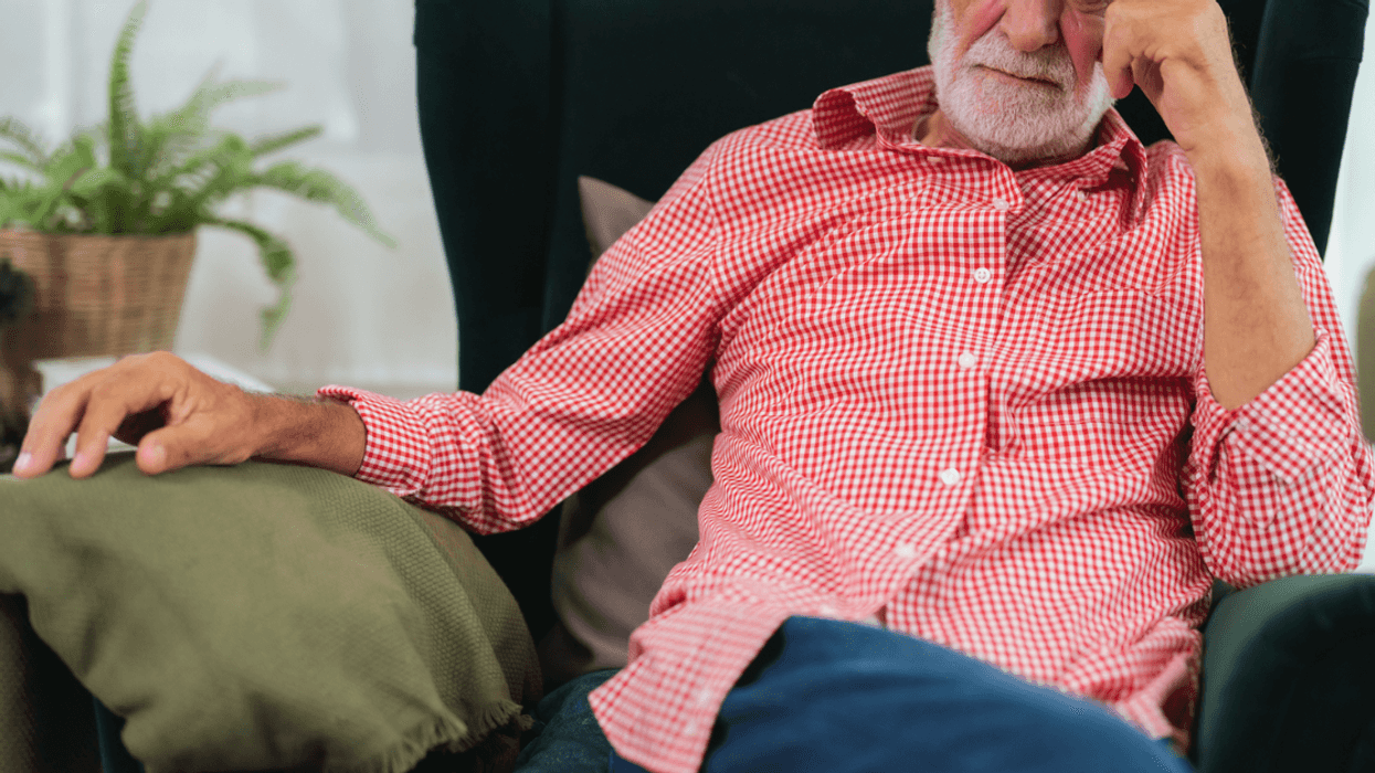 A man sitting back in a lounger chair with his head in his forehead.
