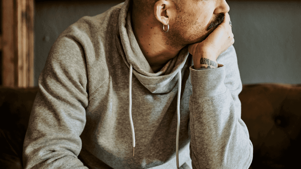 A man sitting with his hand covering his mouth.