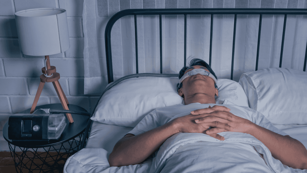 A man sleeping with a CPAP machine attached to his nose.