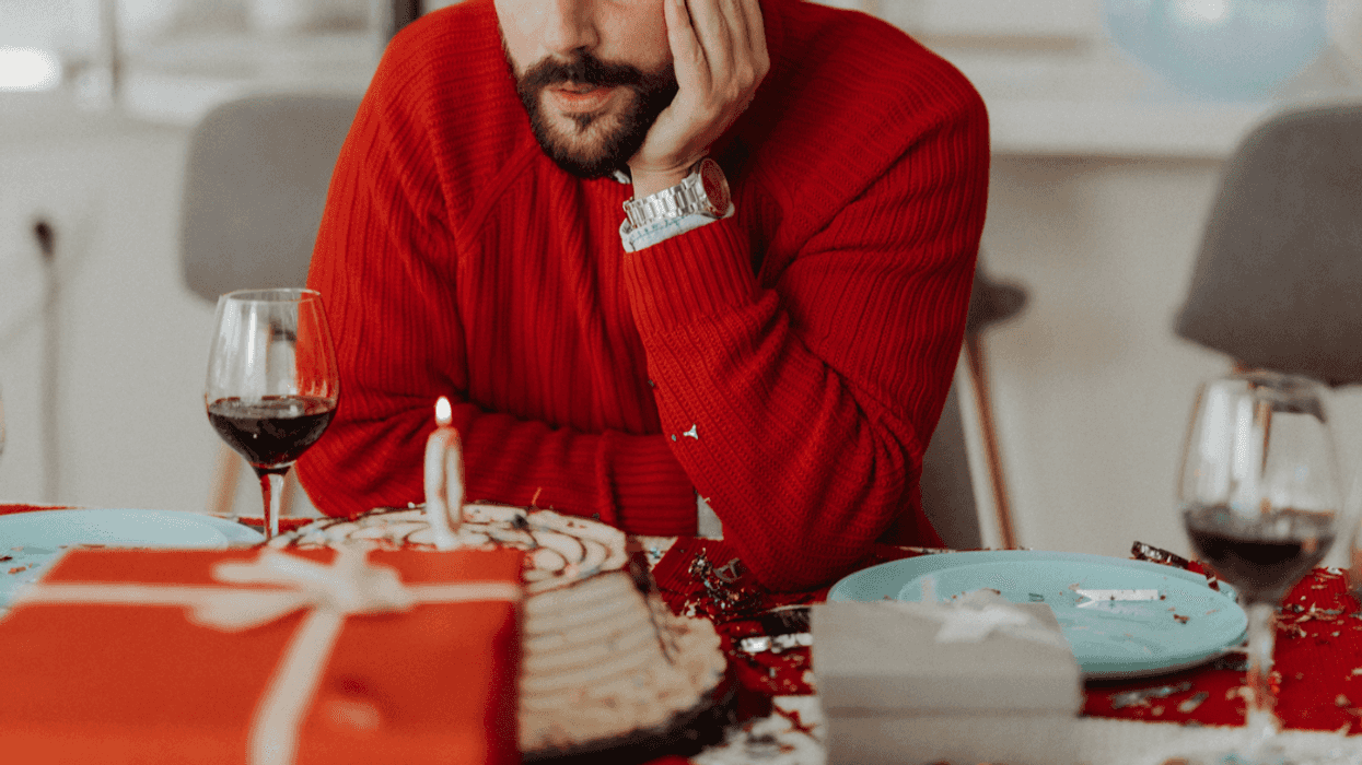 A man staring at his birthday cake.
