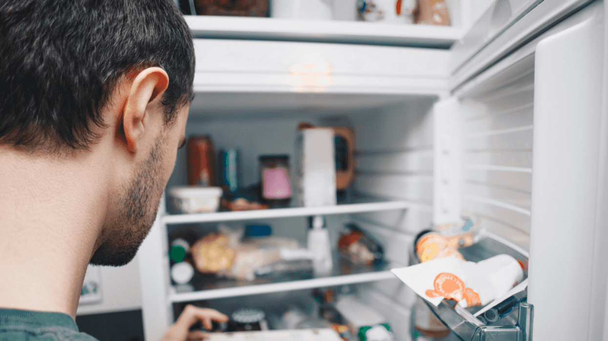 A man staring into a refrigerator.