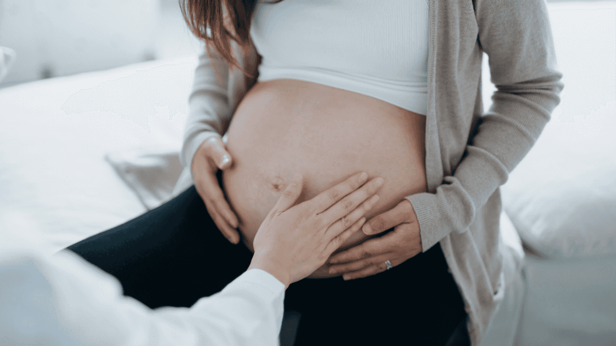 A man touching a woman's pregnant belly.