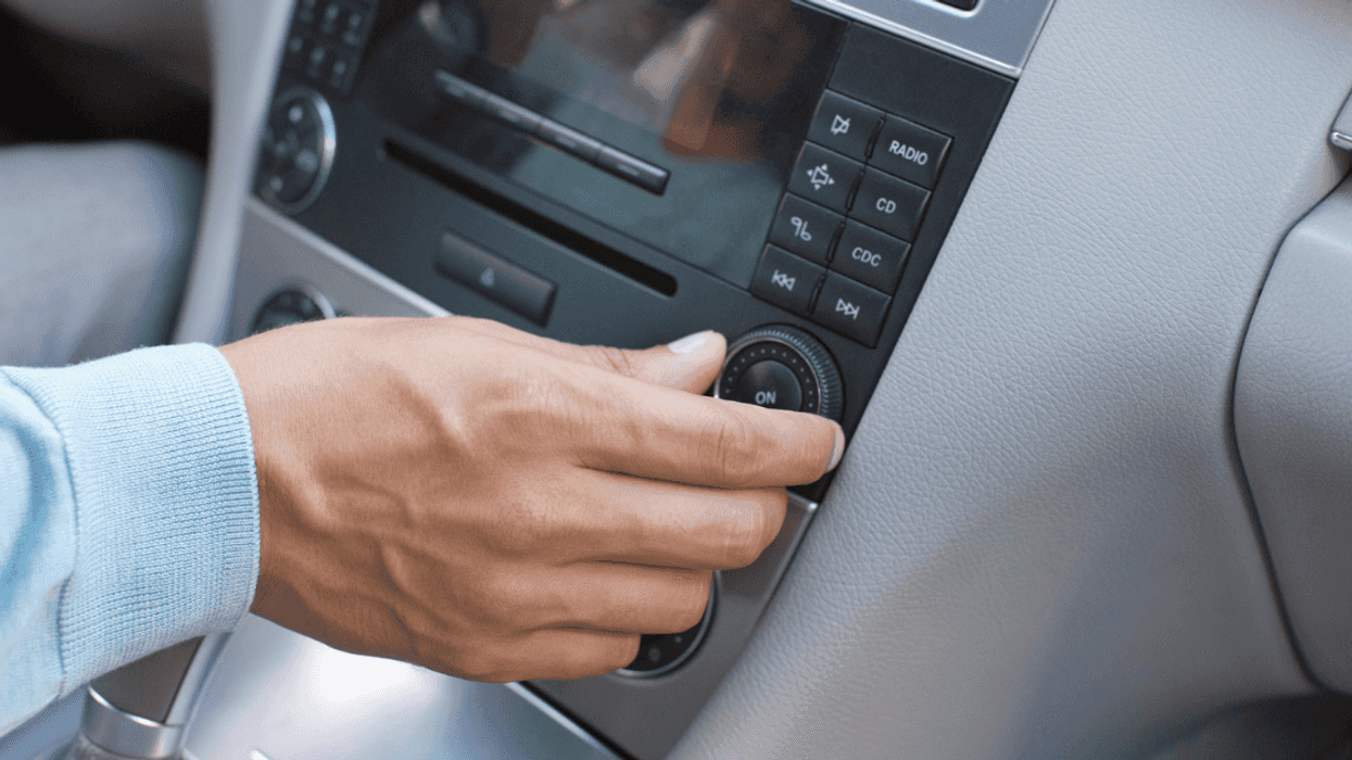A man tuning his car radio.