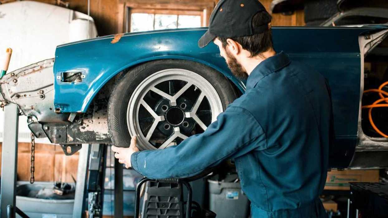 A mechanic works on a car