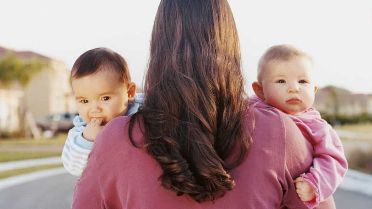 A mom holds twin babies