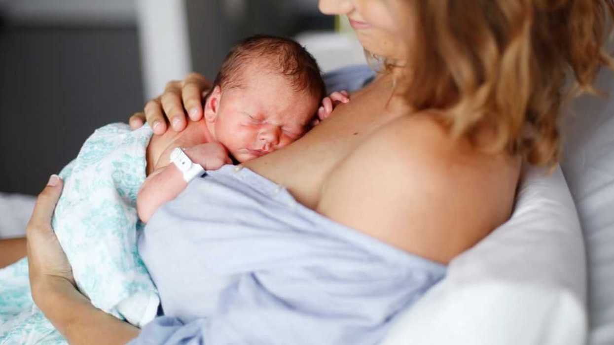 A newborn baby lays on his mother's chest while in the hospital.