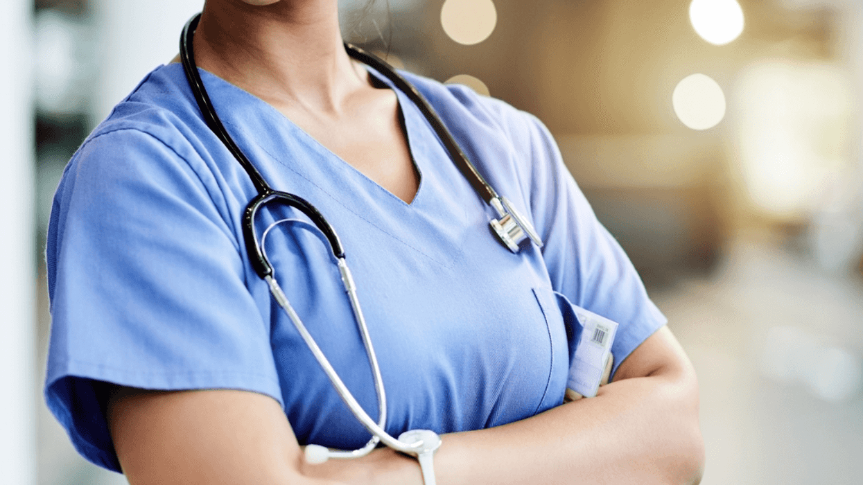 A nurse standing and folding her arms.