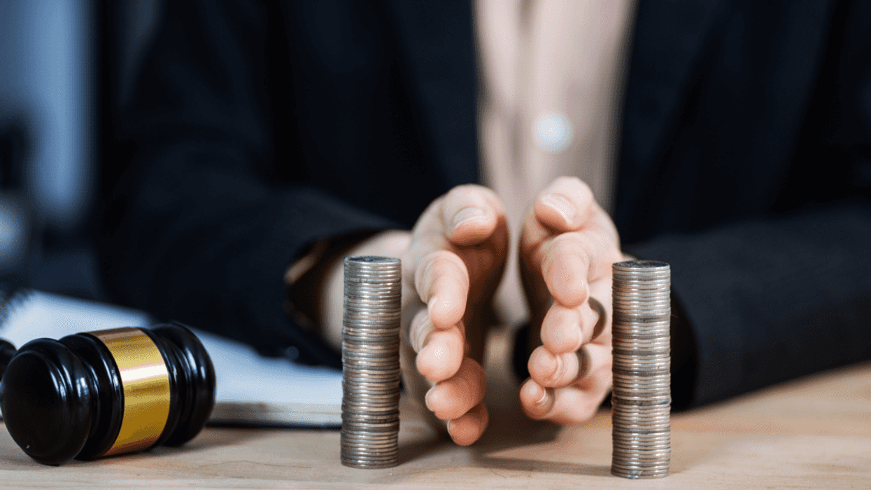 A person dividing two. sets of coins evenly in half.