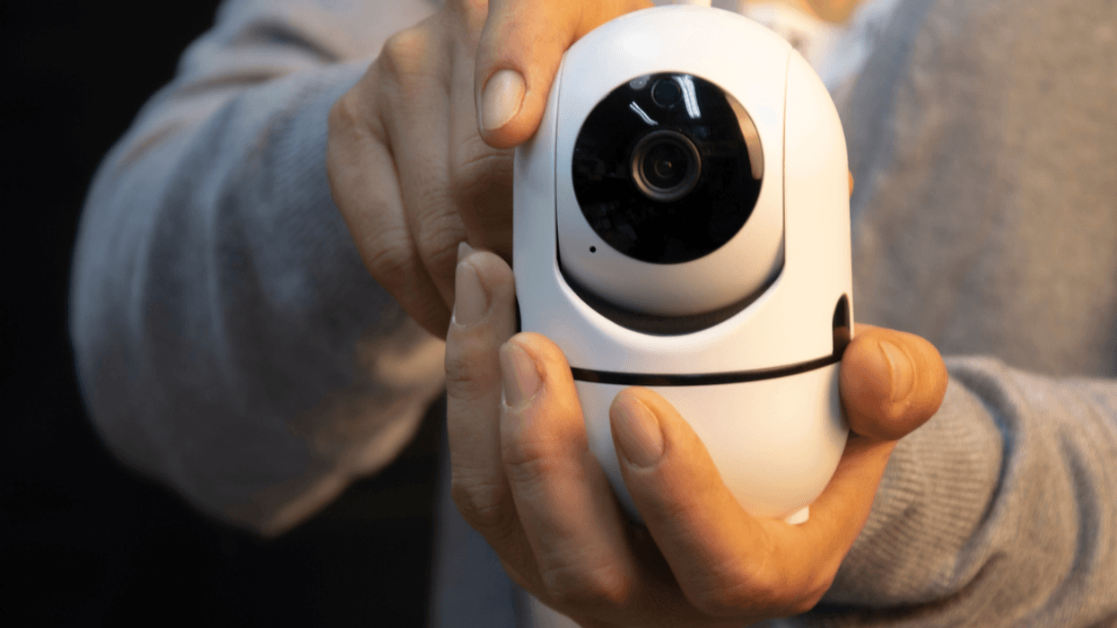 A person holding a nanny cam.