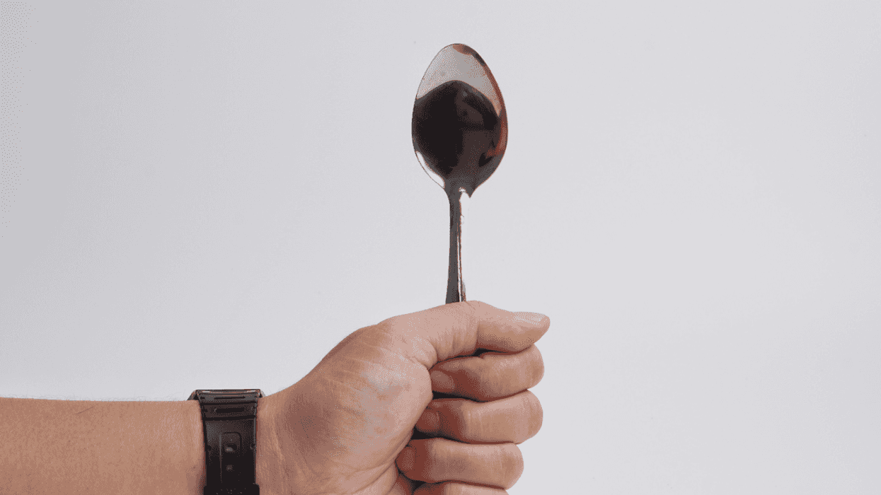 A person holding a spoon upright.