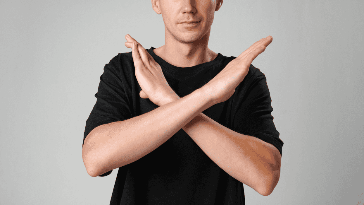 A person holding their arms in an X shape.