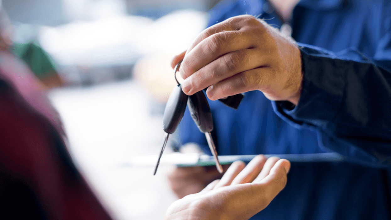 A person passing car keys to someone else