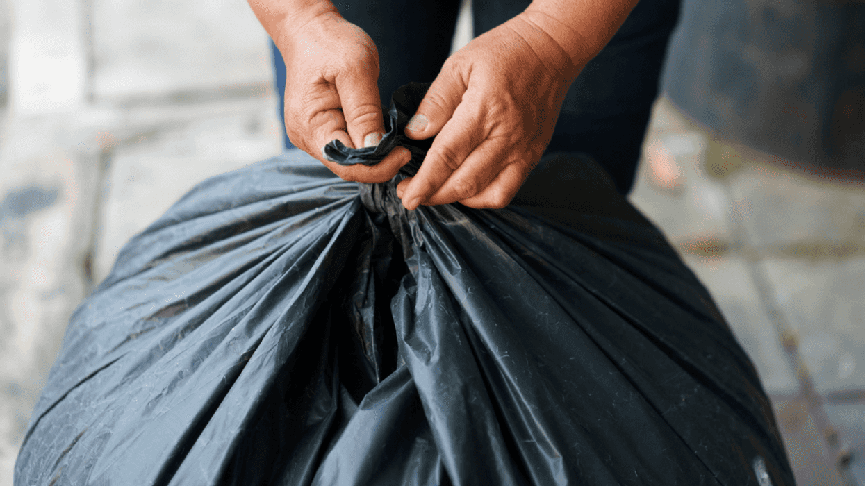 A person wrapping a trash bag.