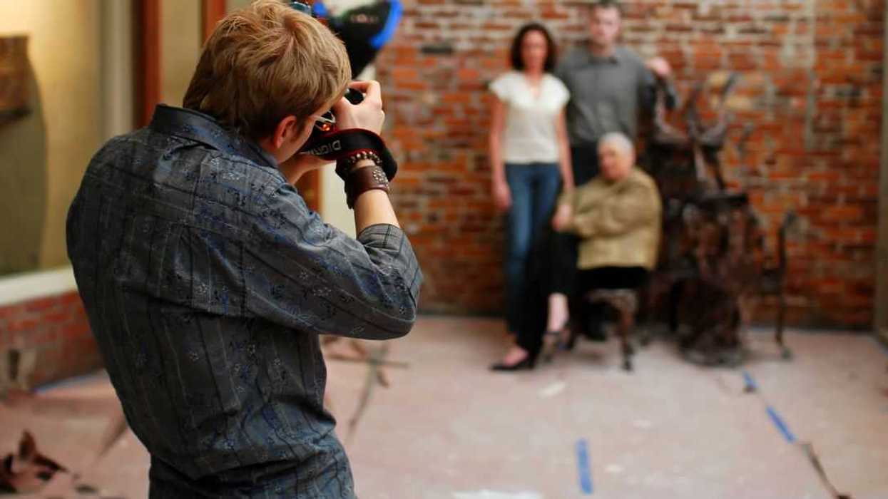 A photographer shooting a couple and their mother in a renovated restaurant.