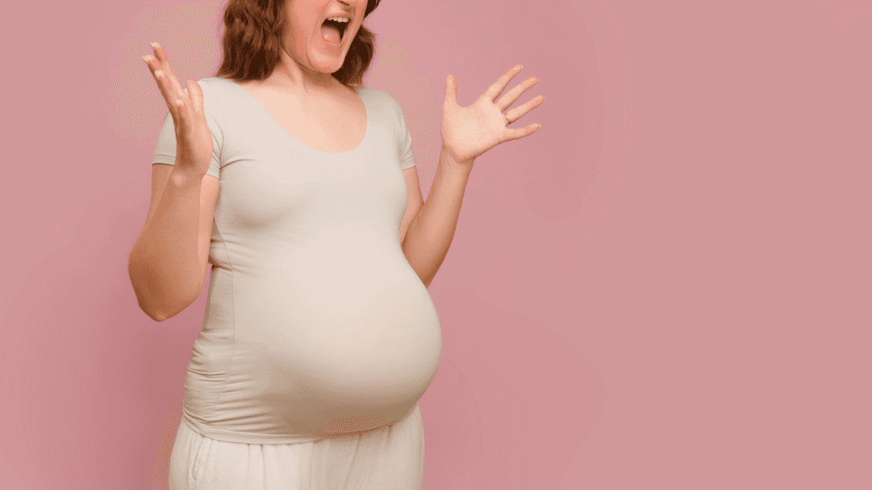 A pregnant woman emphatically holding out her arms and screaming.