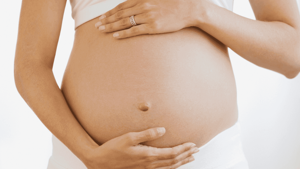 A pregnant woman holding her belly.