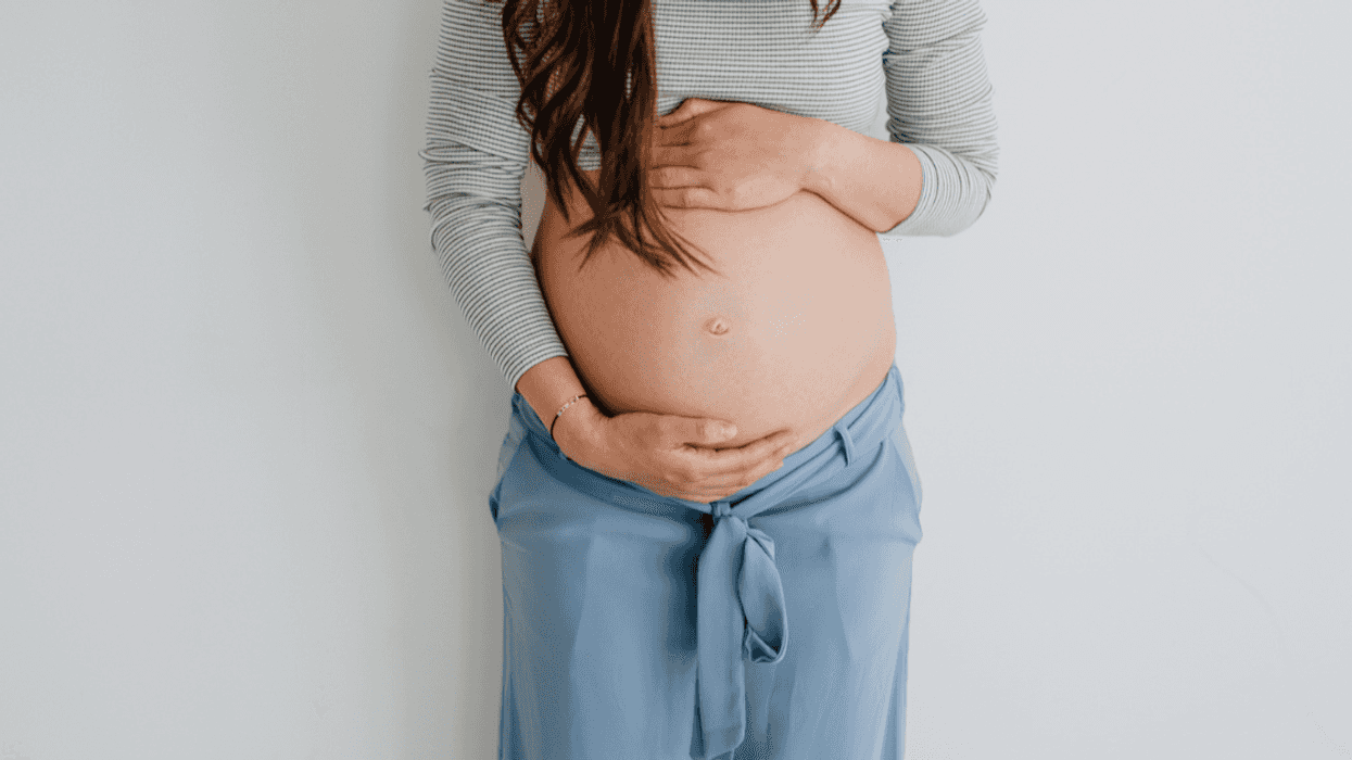 A pregnant woman holding her belly.