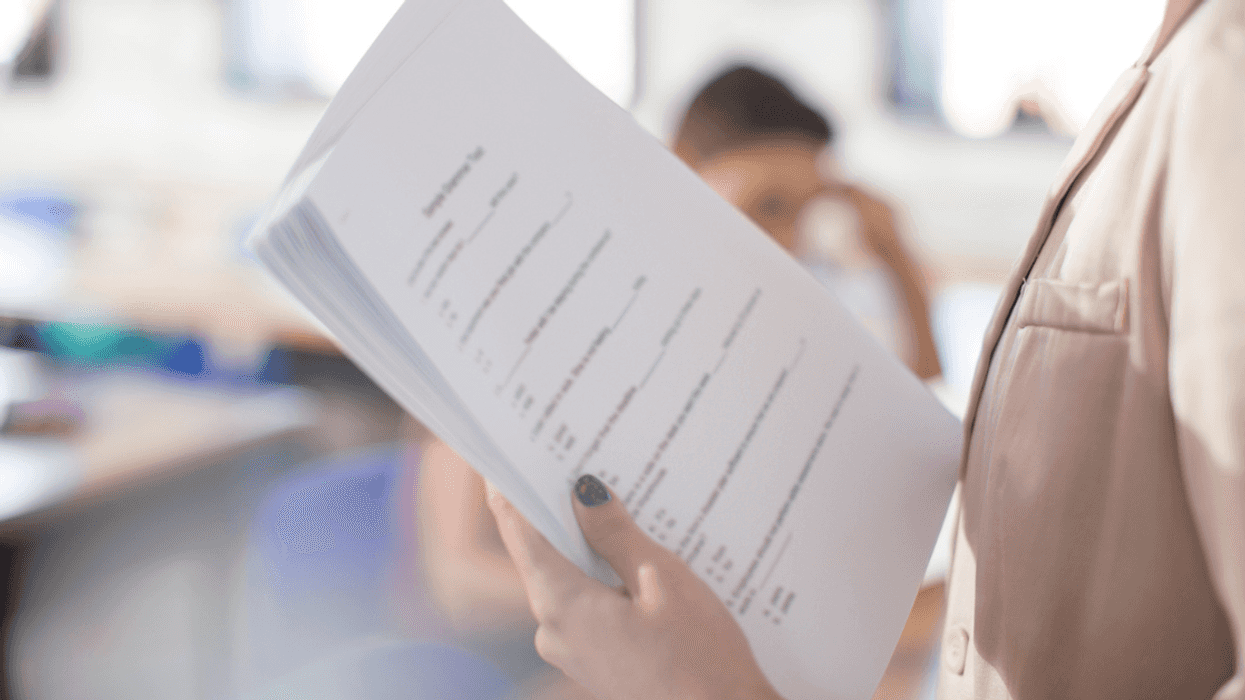 A teacher holding a pile of papers.