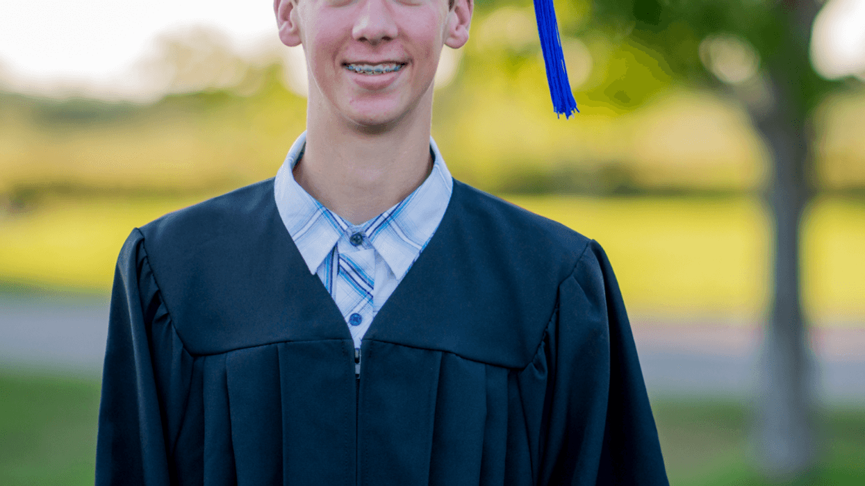 A teen boy in a graduation gown.