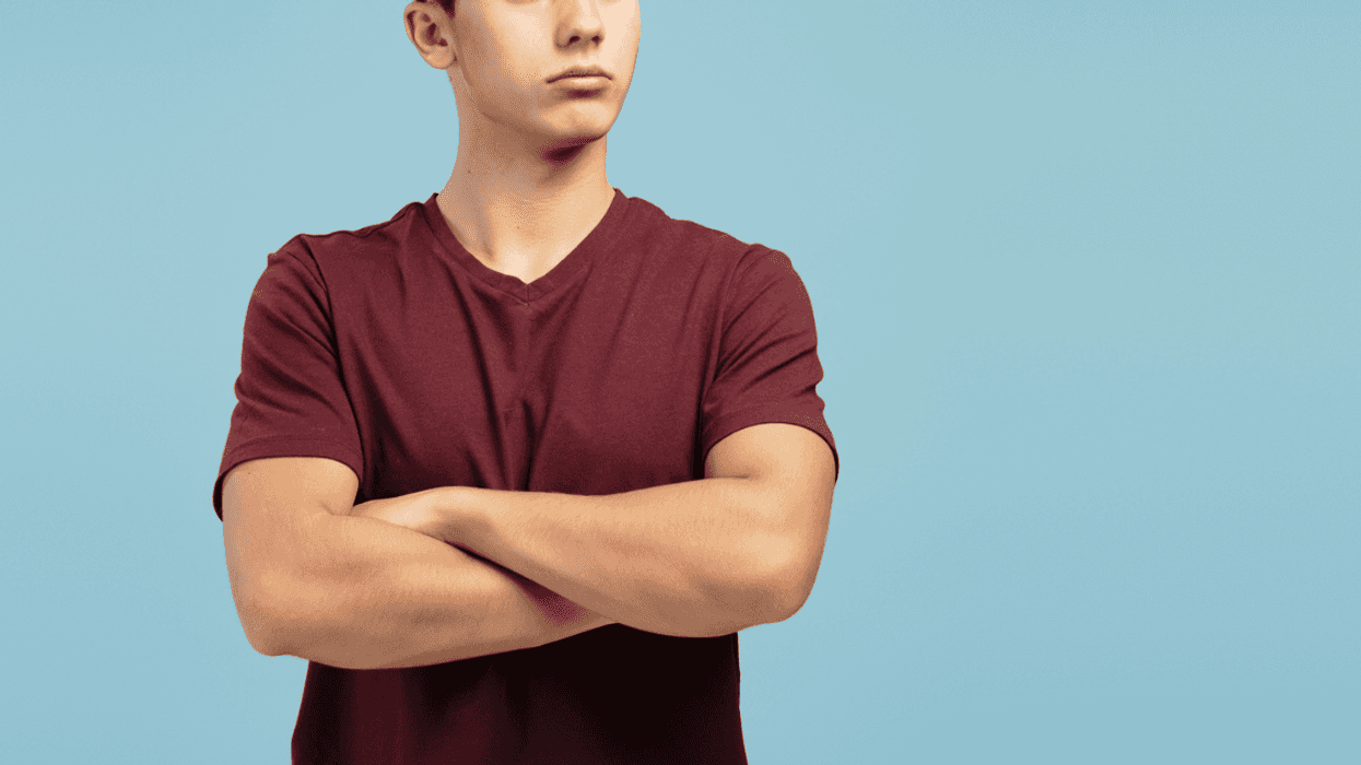 A teenage boy with his arms crossed.