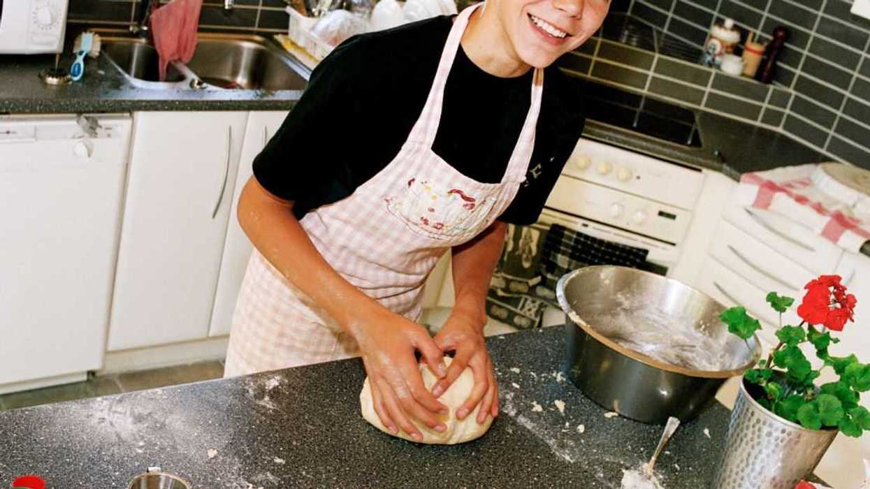 A teenage boy works with dough