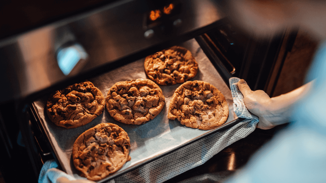 A tray of cookies being taken out of the oven.