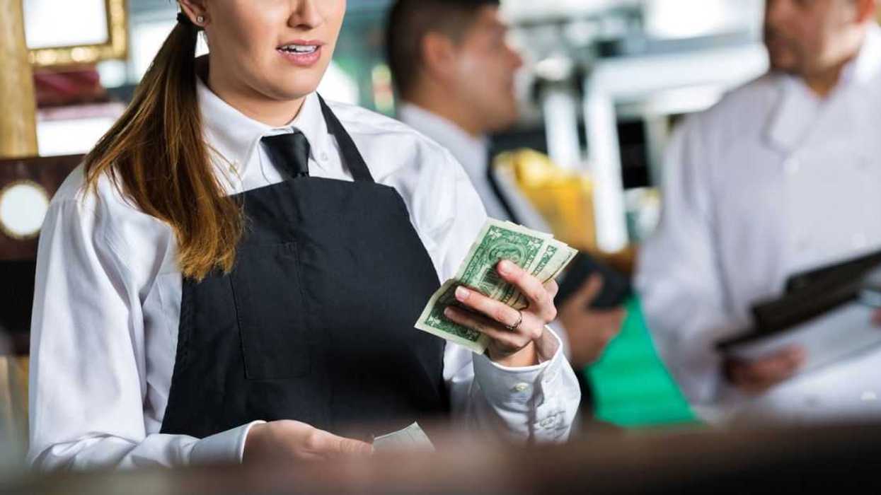 A waitress seems angered by her cash tip