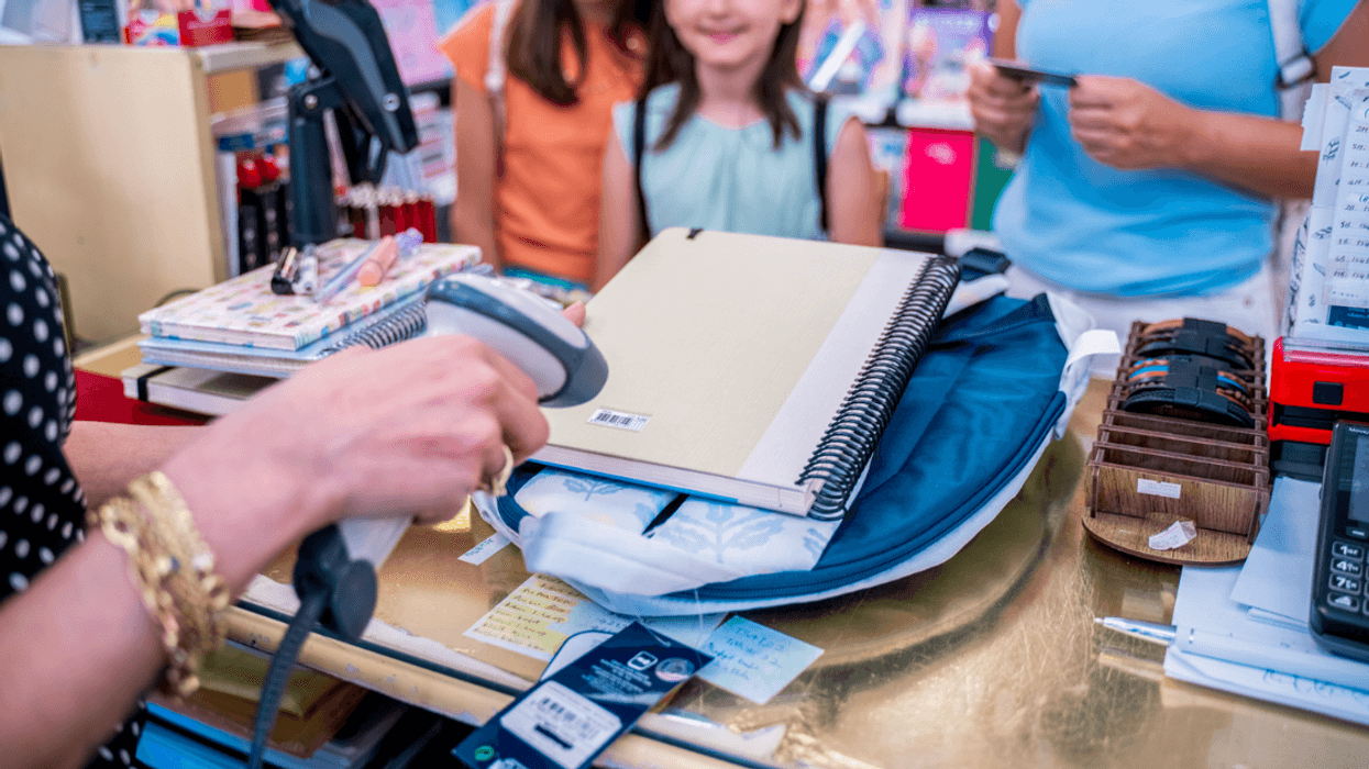 A woman and children buying school supplies.
