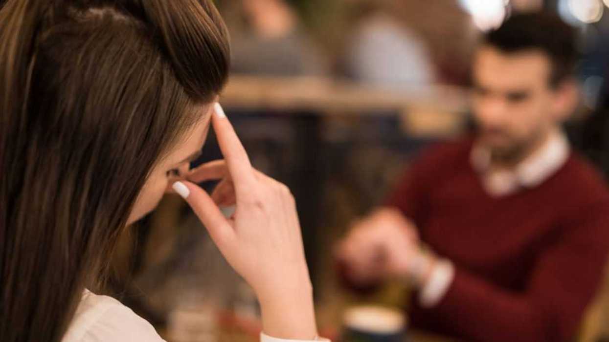 A woman and man are having a tense moment in a restaurant