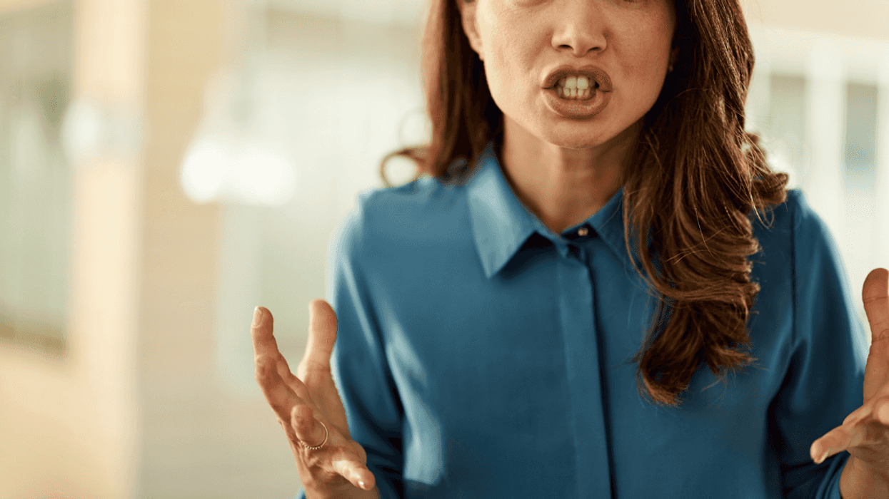 A woman angrily holding out her hands.