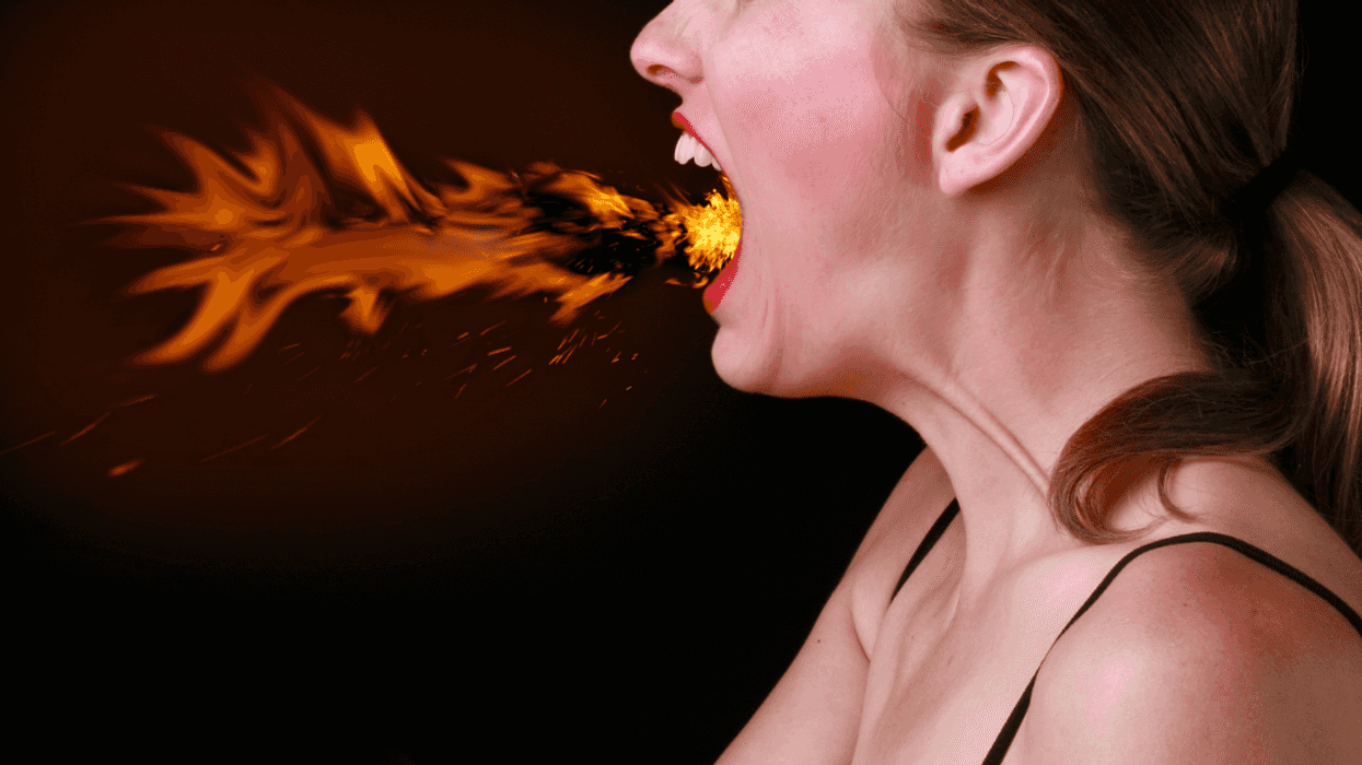 A woman breathing fire from her mouth.