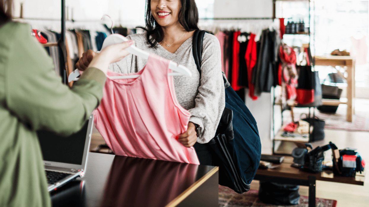 A woman buying a pink dress.