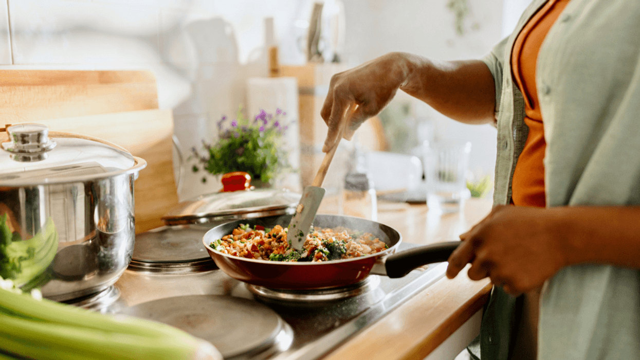 A woman cooking on a stovetop.