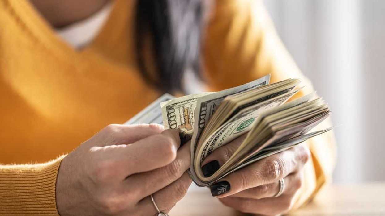 A woman counts many American bills - Close up.