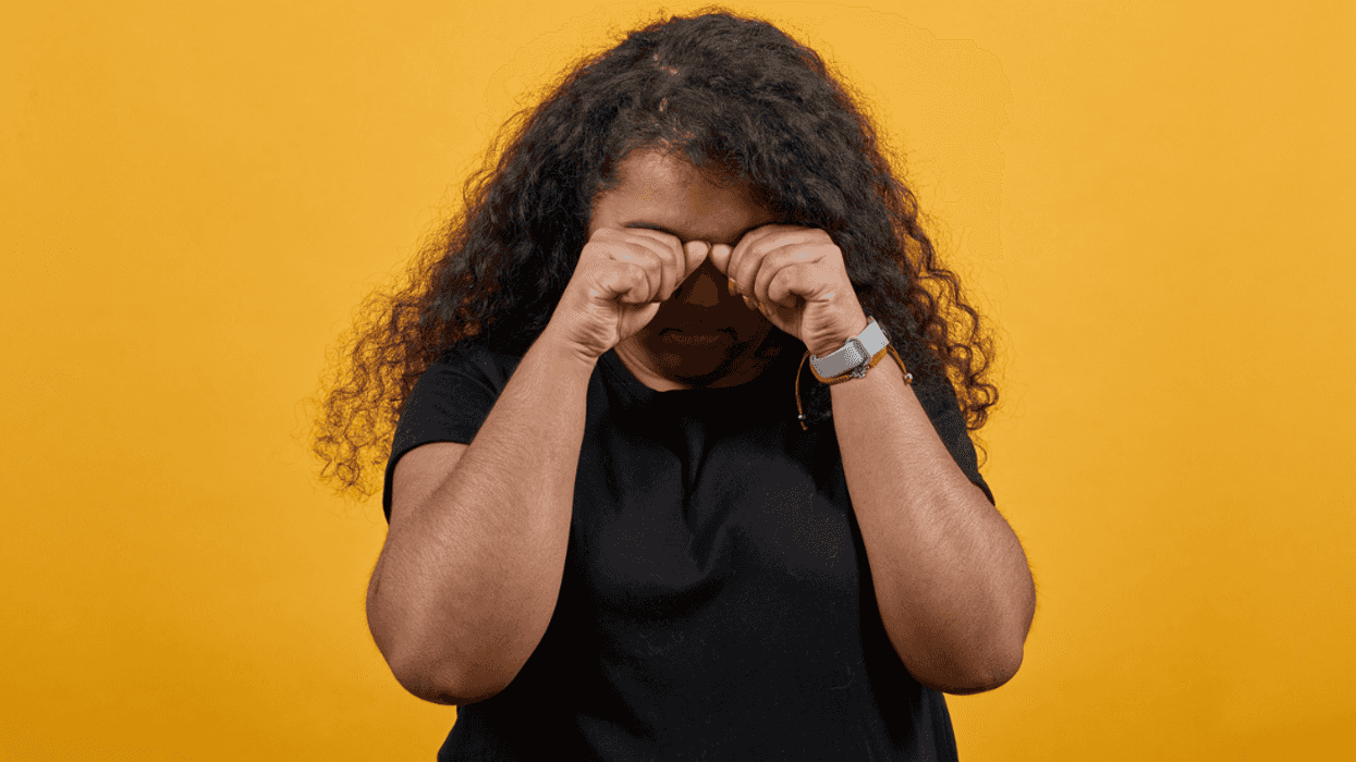 A woman covering her face and crying.