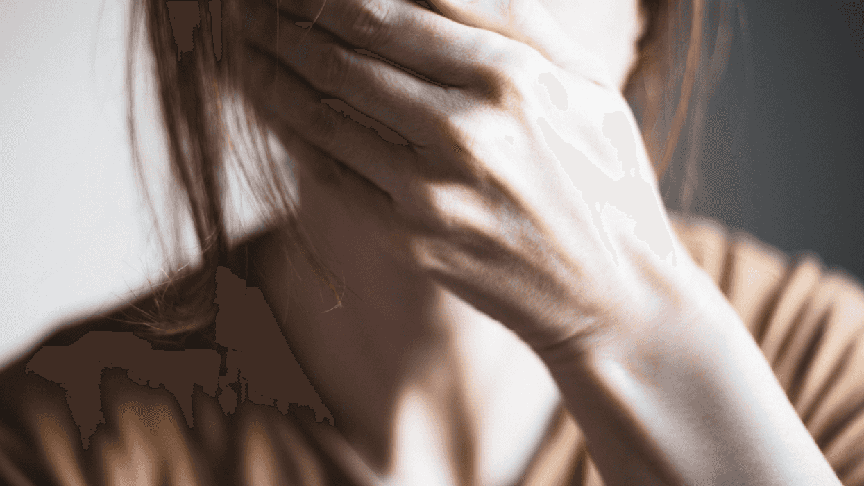 A woman covering her mouth with her hand.