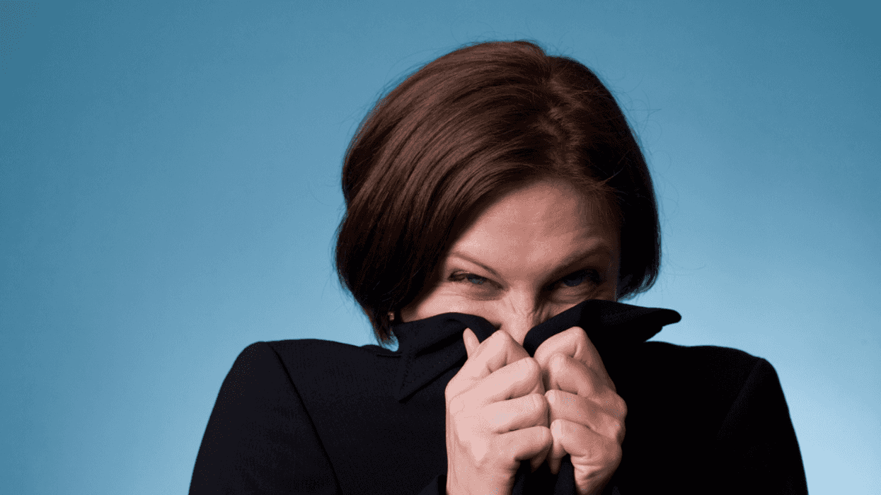 A woman covering her nose with her sweater.