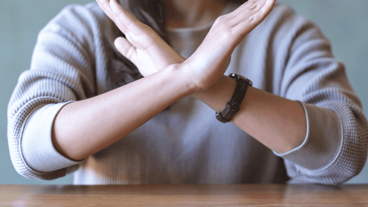 A woman crossing her arms, saying no.