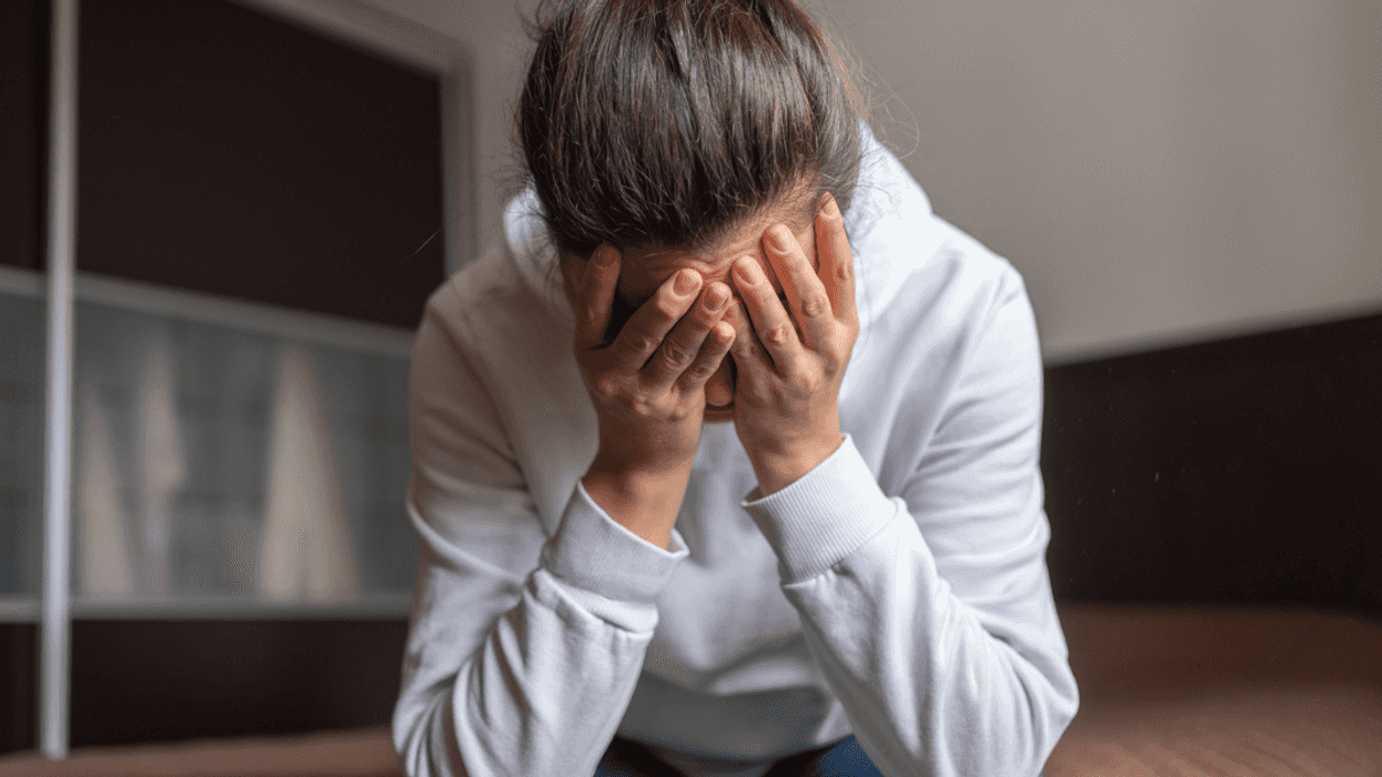 A woman crying into her hands.