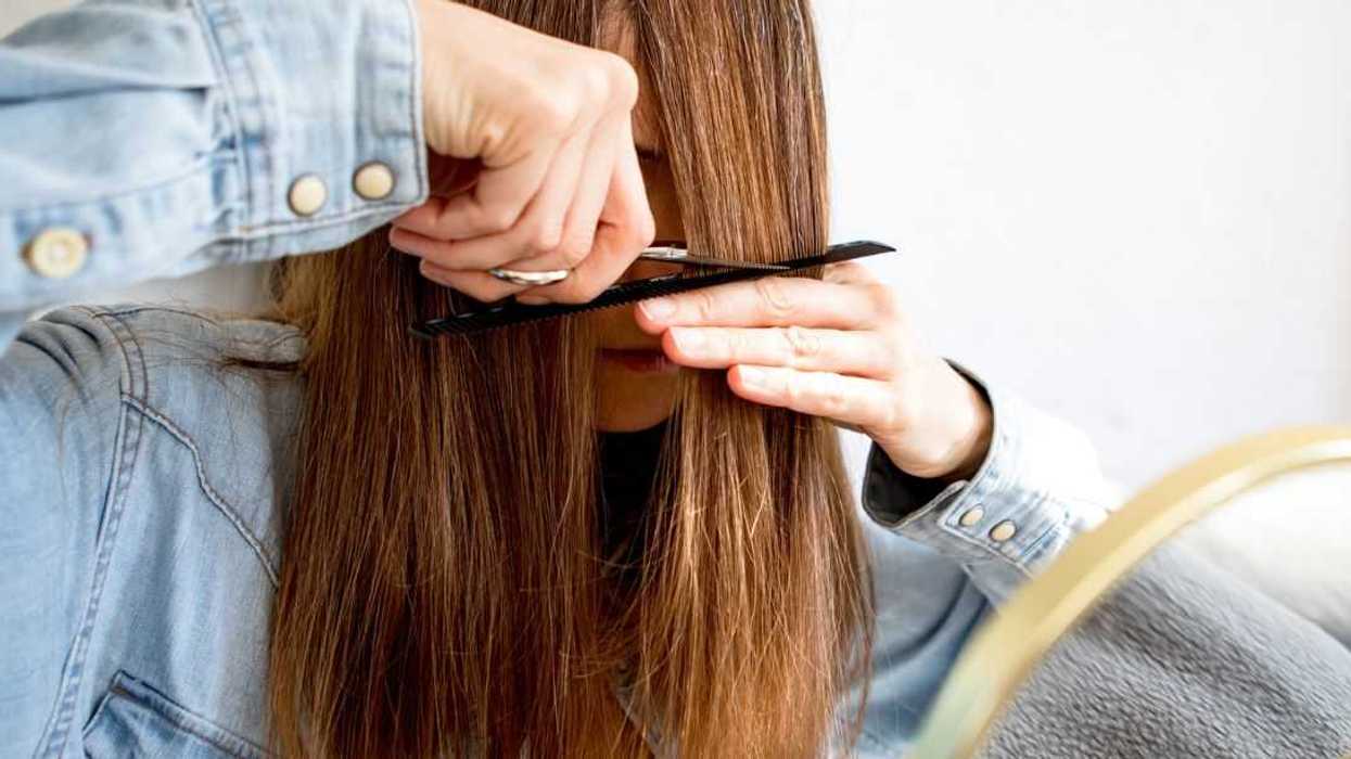 A woman cutting her own hair.