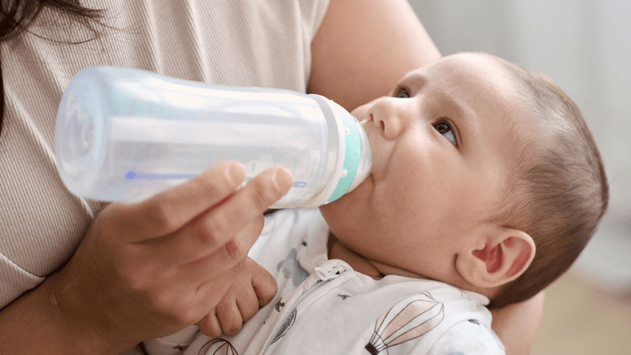 A woman feeding a baby with a bottle.