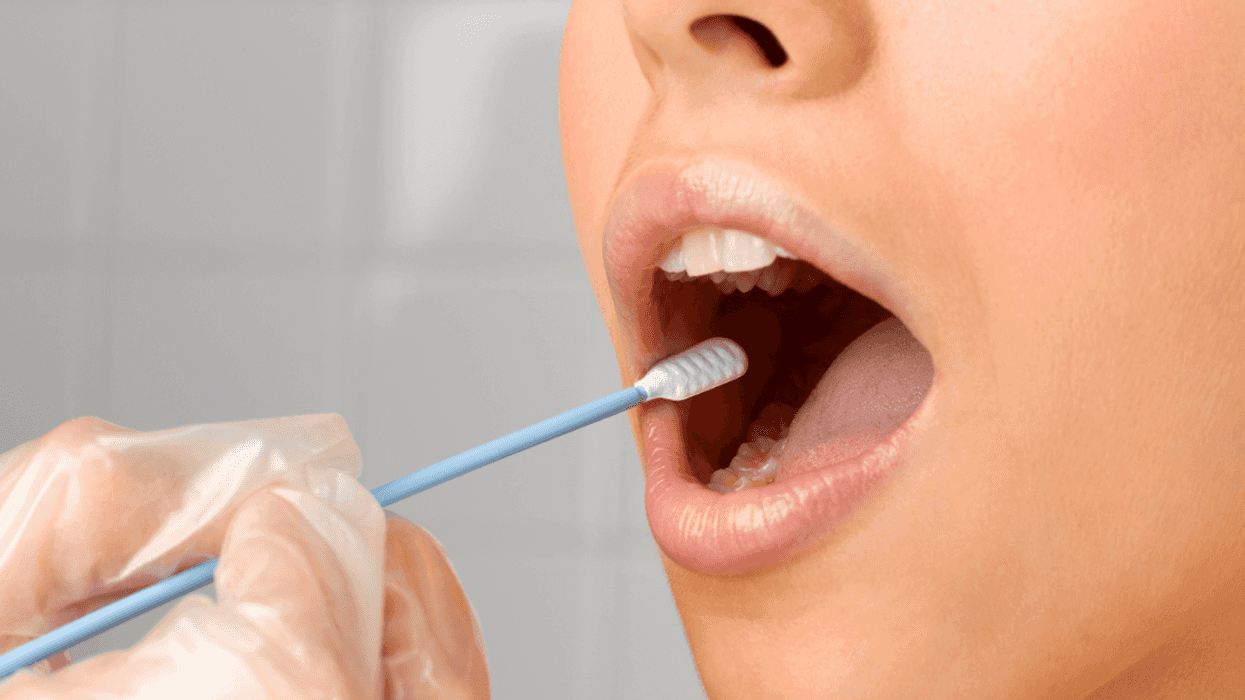 A woman getting a cotton swab inserted into her mouth.
