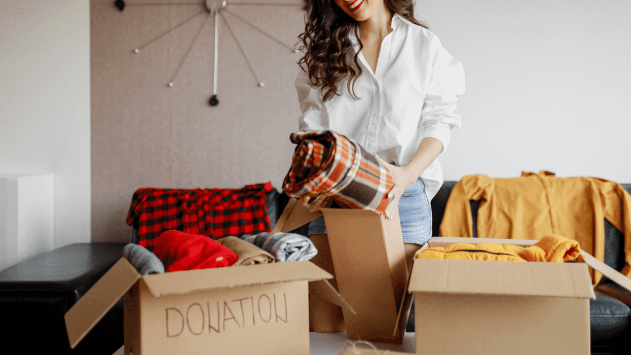 A woman going through boxes of clothes.