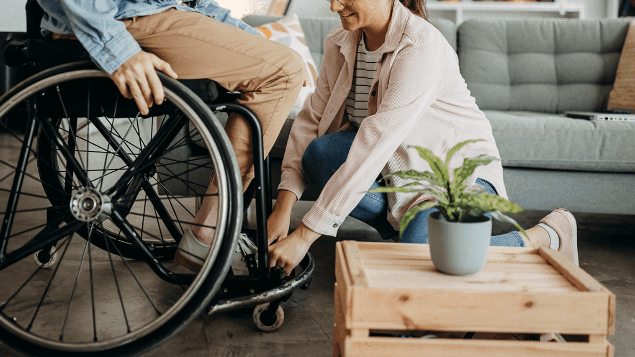 A woman helping a man in a wheelchair.