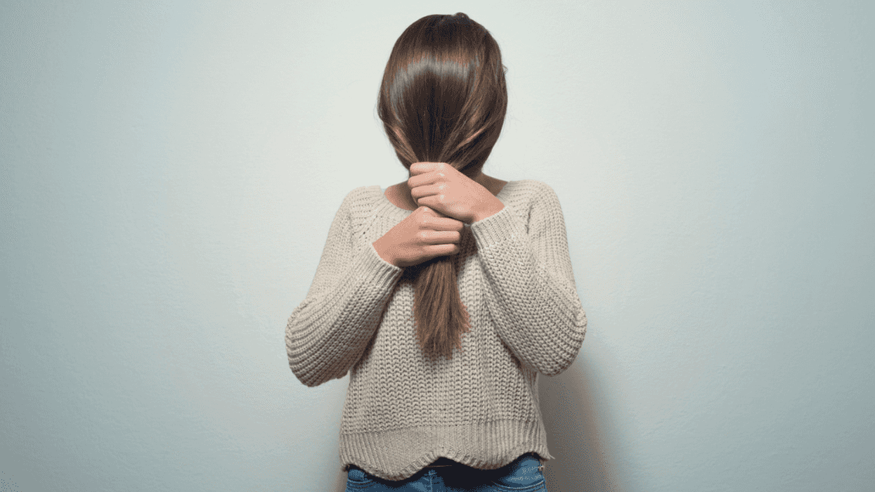 A woman hiding her face behind her hair.