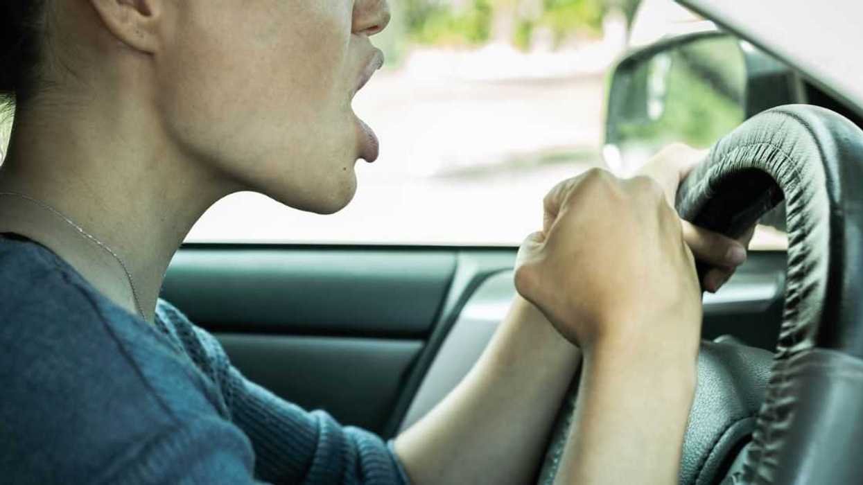 A woman hits her car horn in fury