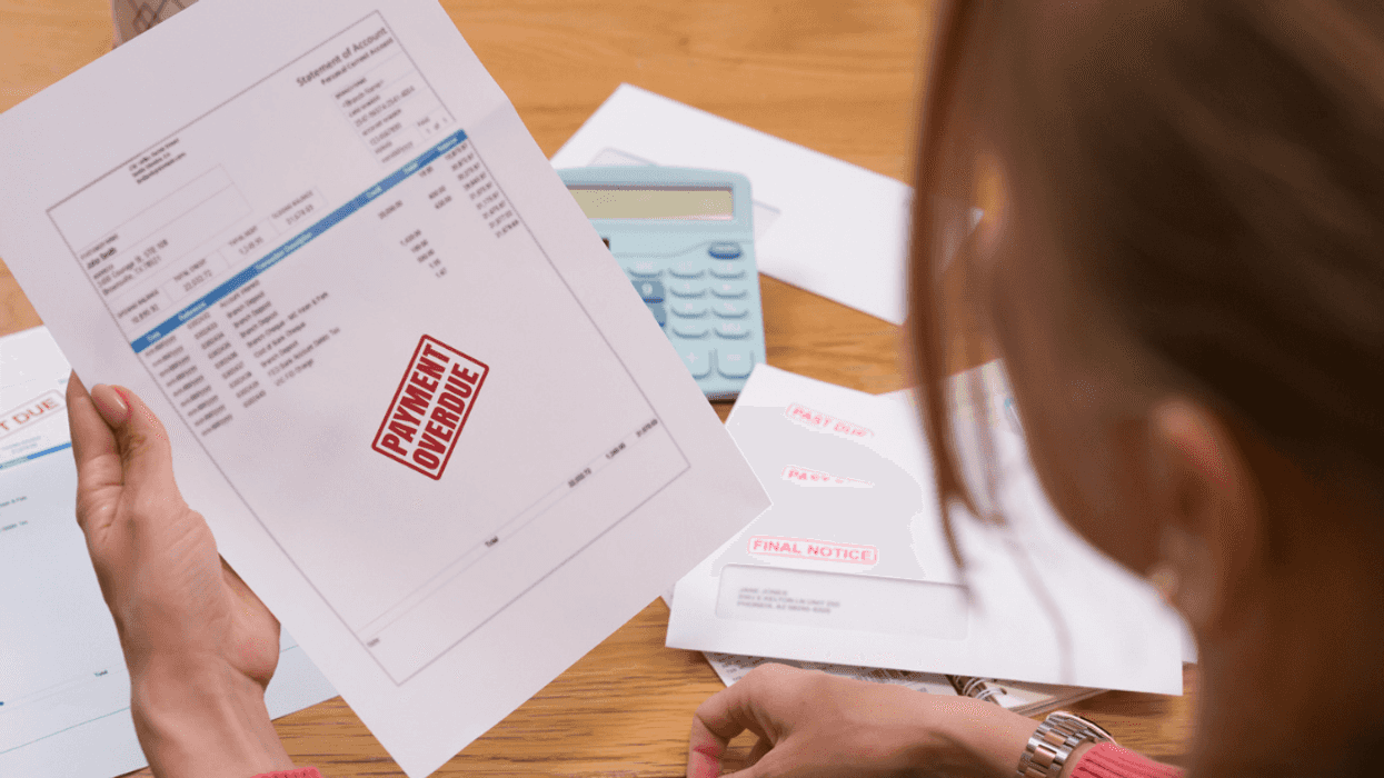 A woman holding a bill saying "payment overdue".