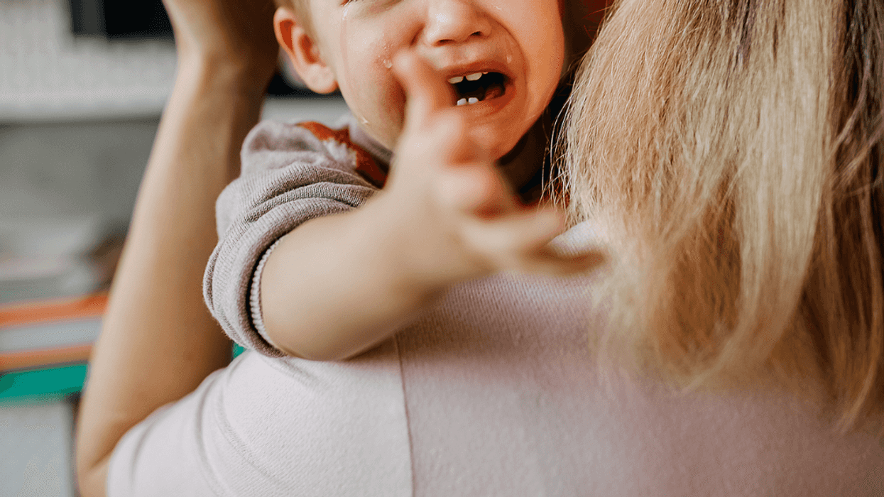 A woman holding a crying baby.