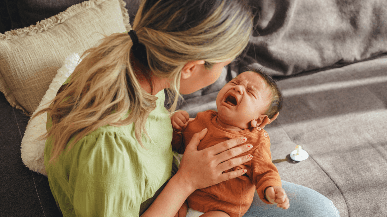 A woman holding a crying baby